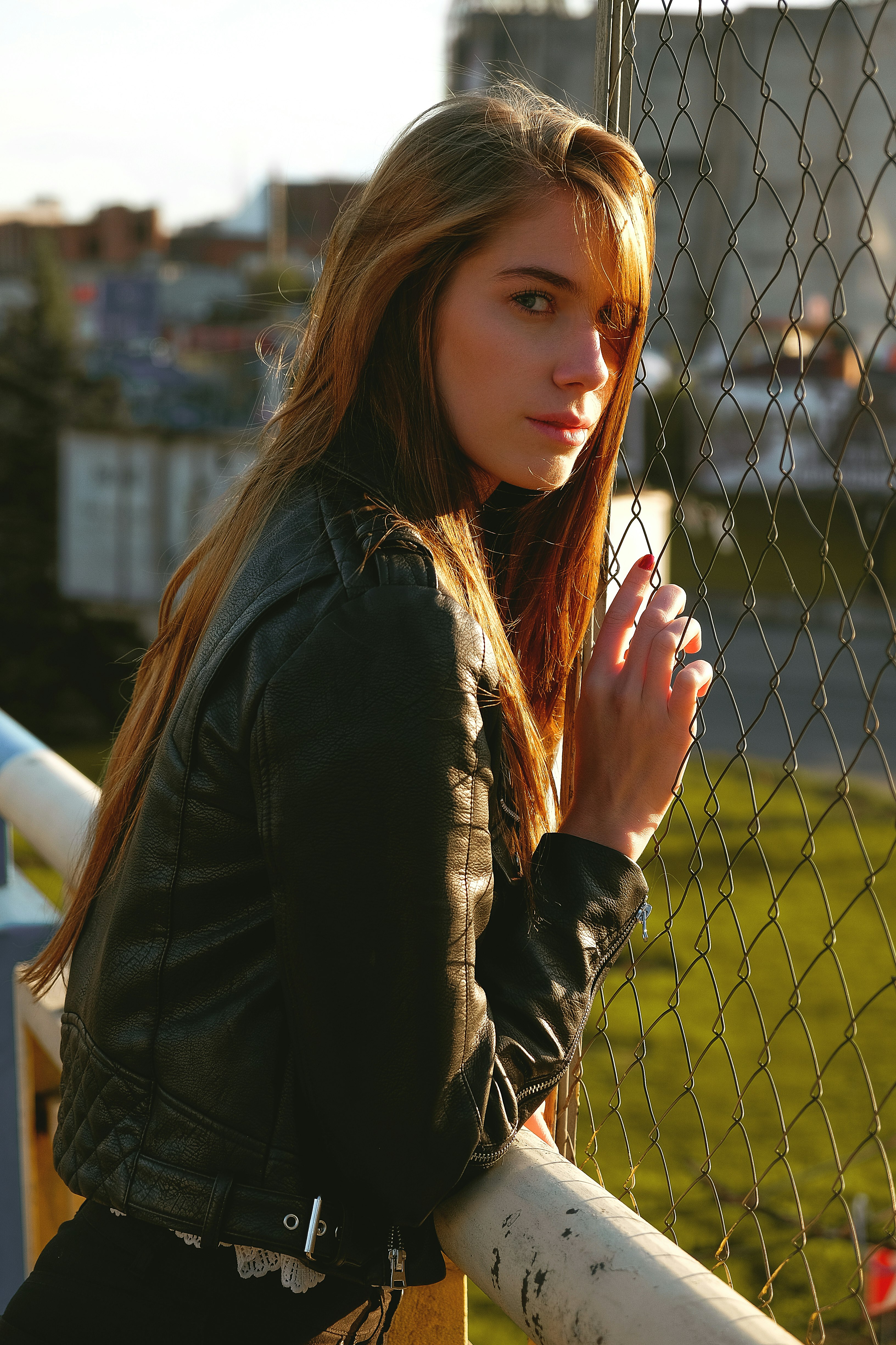 woman wearing black jacket holding fence